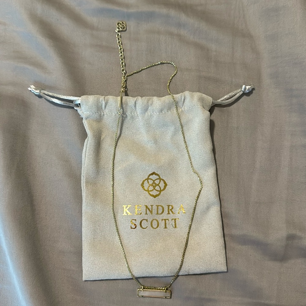 Kendra Scott necklace gold with pinkish white jewel